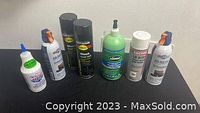Full lot overview showing all 7 items including 2 cans of compressed air, 2 black enamel spray cans, 1 slime tire repair bottle, 1 silver grade anti-seize can, and 1 power steering stop leak bottle
