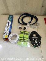 Photo showing 2 blue heavy duty extension cords, a black water jet sprayer labeled Ranger, set of 4 neon yellow high visibility straps, and 4 rolls of double sided tape