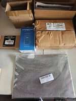 Photo of all lot items arranged on floor with packaging showing various boxes and a sealed 5 pack of screen mesh