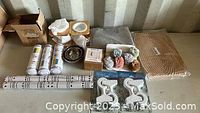 Overview of lot items including adhesive rolls, essential oil holders, bowls, decorative banner, and cheese board in original packaging.