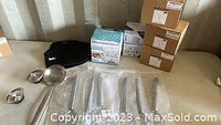 Photo showing ladle strainer, dough whisks, water filters in boxes and Pisces mugs in the background on a table.