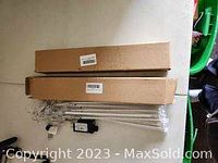 Two cardboard boxes containing LED tube lights and a power adapter.