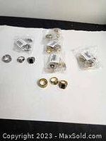 Photo showing multiple men's rings laid out on a white surface, including individual bags and loose rings.