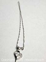 Sterling silver necklace with a heart-shaped pendant shown in full chain length and close-up detail of the pendant.