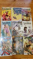 Full lot of 9 comic books laid out on wooden surface including six Hawkeye issues, one Ms Marvel, one Spider-Man, one Iron Fist.