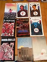 Nine comic books laid out on a wooden surface showing covers including Mazebook (4 issues), Purgator, Crimson Cage, Barbarella, and an unknown comic.