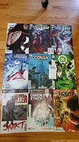 Nine Marvel comic books laid out flat on wood floor showing full cover artwork.