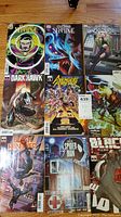 Photo showing nine Marvel comic books placed on a wooden floor, including Doctor Strange, Dark Hawk, Gwenverse, Avengers Forever, Black Panther, Spider-Man, and Black Widow.