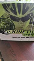 Front of box with partial Kinetic by Kurt branding and image of cyclist wearing glasses and helmet.