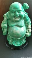 Front view of green Buddha statue showing full figure and base.