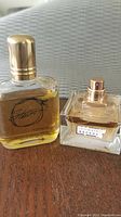 Photo of Stetson cologne bottle and Intimately Beckham fragrance bottle side by side on wood surface.