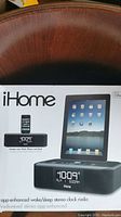 Front box image showing iHome stereo clock radio with iPad docked and digital clock display