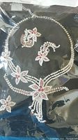 Full jewelry set including necklace, earrings, bracelet and brooch showing floral rhinestone design