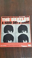 Front cover of The Beatles 'A Hard Day's Night' original motion picture soundtrack LP with orange background and black and white faces