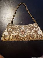 Full view of one purse showing body shape, bead detail, and braided handle