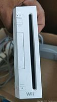 Front and side view of white Nintendo Wii console showing power, reset, eject buttons and disc slot