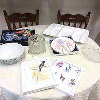 Full view of the household items arranged on a table including artwork, bowls, trays, and hot plates