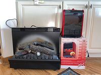 Electric fireplace insert and portable air heater shown together with the heater on its box and the fireplace insert next to it.