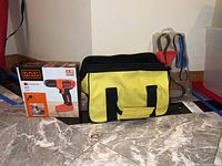 Black+Decker drill box, Stanley toolbox, and hand tools (pliers and screwdrivers) visible on floor.