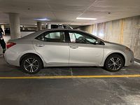 Left side profile of silver Corolla sedan in parking garage