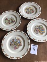 Four Royal Doulton Bunnykins plates showing varying bunny-themed patterns, each 8 inches in diameter, with a bunny border.