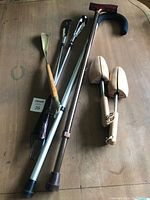 Full view of the lot on a wooden surface including walking canes, shoe horns, and shoe stretchers