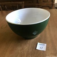 Side and partial interior view showing green exterior and white interior ceramic mixing bowl with badge
