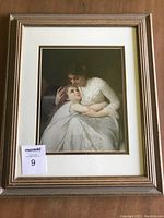 Full view of the framed print showing the mother and child with mats and frame visible.