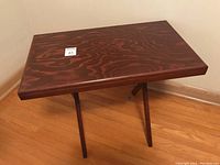 Full view of handcrafted oak TV table showing rectangular top and folding legs set up in locked position.