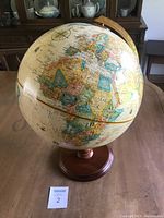 Full view of the globe mounted on a wood base showing continents and countries