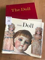 Book with dust jacket showing antique dolls in color and black/white photographs.