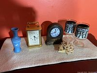 Overall image of the lot showing all items on a table against a red wall