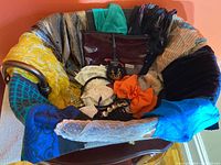 Photo showing entire lot of scarves and hair accessories arranged in a chair, various patterns and colors visible.