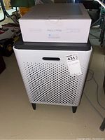 Front view of Coway Airmega air purifier with boxed Max2 filter on top.