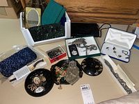 Photo of assortment of costume jewelry, clutches, boxes, and trays laid out on table