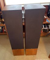 Front view of the pair of Boston T1000 XL 04218 floor standing speakers with wood and black cloth cover.
