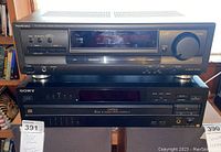 Front view of Technics SA-EX100 receiver on top of Sony CDP-CA70ES disc player showing front panels including buttons, display panels and labels.