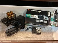 Photo of FujiFilm FinePix Z1 camera with box, Kodak camera and five binoculars