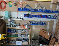 Wide view of shelving and wall bins filled with assorted hardware items.