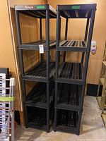 Photo showing two assembled black plastic shelving units side by side showing height and shelving count.