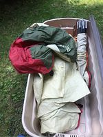 Open tote showing folded tent fabric and wrapped tent poles inside.