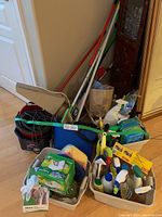 Photo showing buckets containing mops, cleaning cloths, sprays, and various accessories.