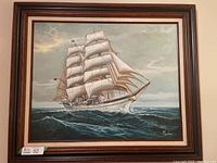 Full view of the framed painting showing a clipper ship in rough seas with cloudy sky.