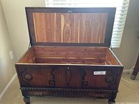 Hope chest with lid open showing cedar wood interior and decorative front panel