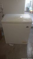 Front view of white Igloo chest freezer with closed lid.