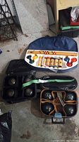 Two sets of lawn bowls in black carrying cases and a wooden croquet set in a blue fabric case containing mallets, balls and stakes.