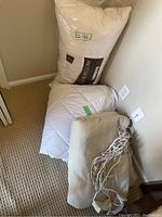 Photo of king feather pillow still in packaging, king mattress cover folded, and heated blanket partially visible.