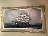 Full view of framed oil painting depicting a multi-masted sailing ship at sea