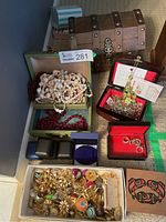 Full overview of the treasure chest, several jewelry cases, and assorted jewelry items including pearl and red beaded necklaces.