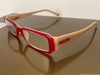 Side view showing red front frame and nude temples with Chanel logo plaque